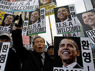 South Korean demonstrators welcome US President Barack Obama outside the US Embassy in Seoul on Thursday during his short visit there. <b>AP</b>