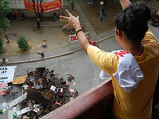 A Polytechnic University of the Philippines student in Manila throws out broken chairs on Thursday to protest against tuition fee hike. <b>GMANews.TV</b>