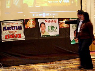 Hotel guests pass by campaign posters including an inverted 'Erap-Binay' near the Wallace Business Forum venue in Makati on Thursday. <b>Mark Adrian</b>