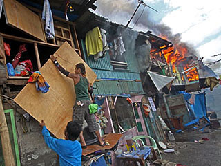 Residents of Tiongco and Herbosa Streets in Tondo, Manila try to save their belongings while fire razes a number of houses on Thursday. <b>Danny Pata</b>
