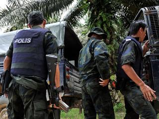 Malaysian police escort dead comrades killed by mortar fire